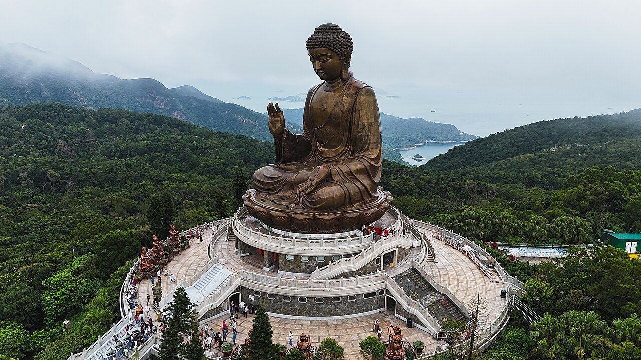 The Tian Tan Buddha statue on Lantau Island, Hong Kong, with forested hills behind
