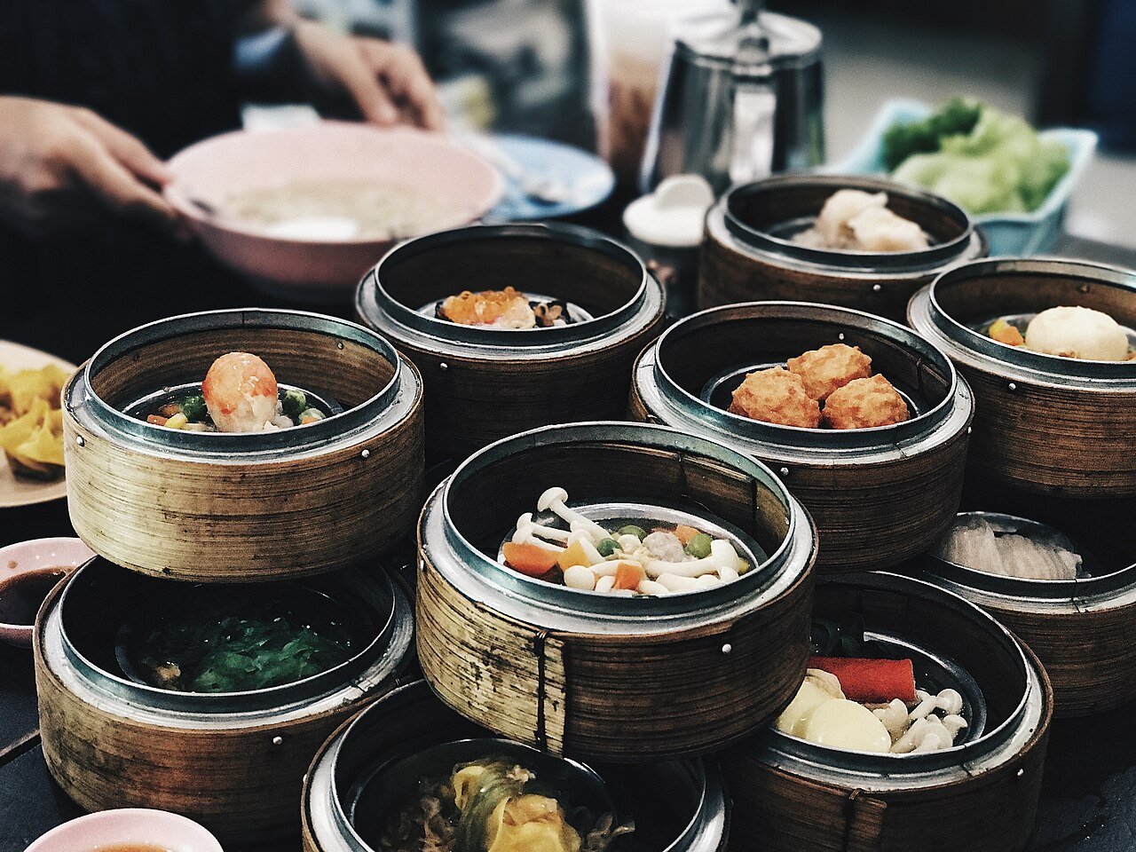 Steamed bamboo baskets of dim sum on a table, with a teapot