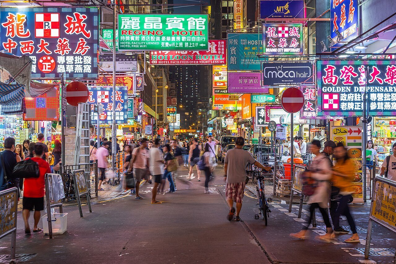 Neon signs glowing over a crowded street in Mong Kok, Hong Kong, at night