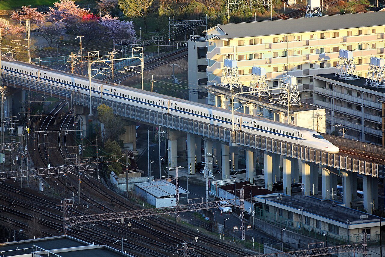 An N700 Series Shinkansen bullet train crossing an elevated viaduct in Japan