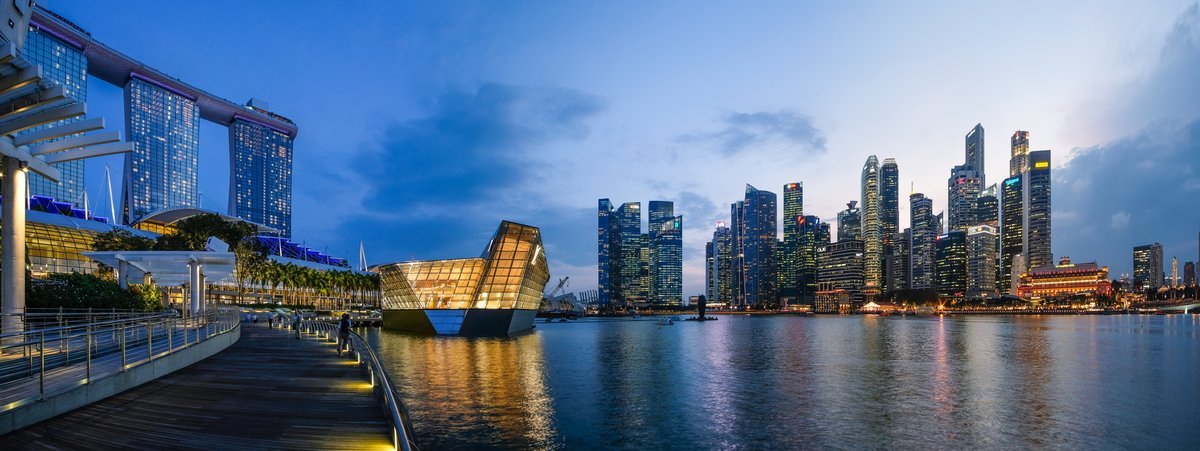 The Singapore skyline at dusk, Marina Bay Sands and the Supertrees glowing against a purple sky